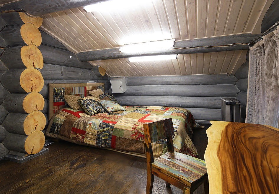 Уютная спальня в мансарде деревянного дома