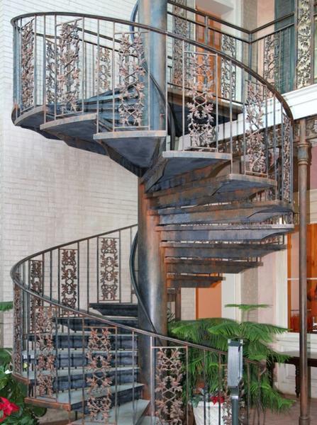 В интерьере загородного дома стильно и изысканно будет смотреться металлическая винтовая лестница с элементами художественной ковки