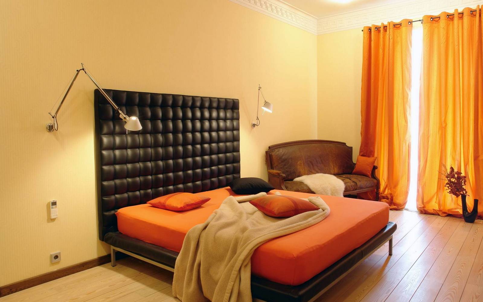 Кремово-оранжевая спальня с черной кроватью